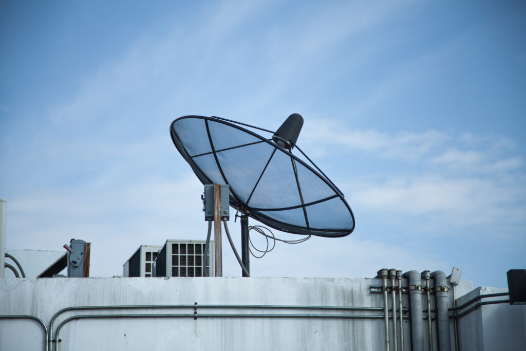 low angle view antenna by building against sky